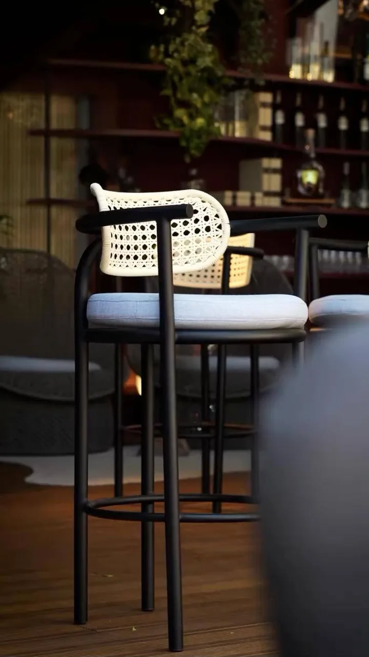 Banqueta alta com encosto de palhinha junto ao bar