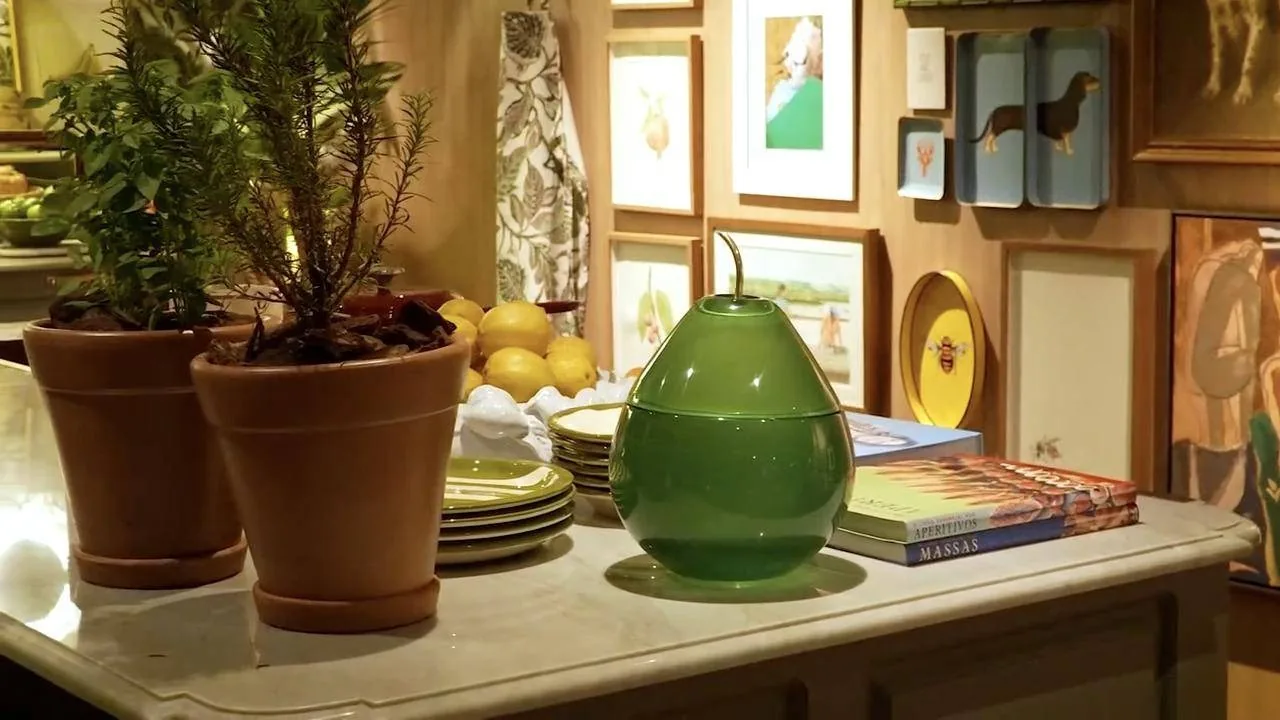 Bancada com vasos de ervas, limões e um pote verde em forma de pera
